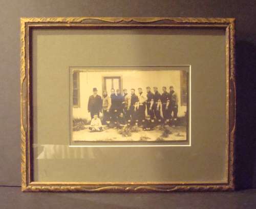 Early Base Ball Team in Black Uniforms in Front of White Building